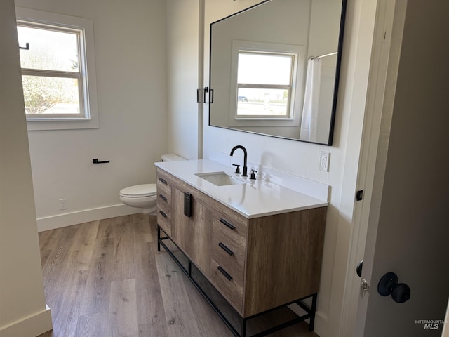 bathroom featuring vanity, wood finished floors, curtained shower, toilet, and baseboards