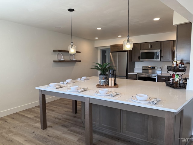 kitchen featuring dark brown cabinetry, baseboards, recessed lighting, light wood-style flooring, and appliances with stainless steel finishes