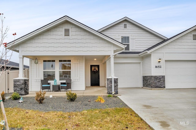 view of front of home with covered porch, fence, and concrete driveway