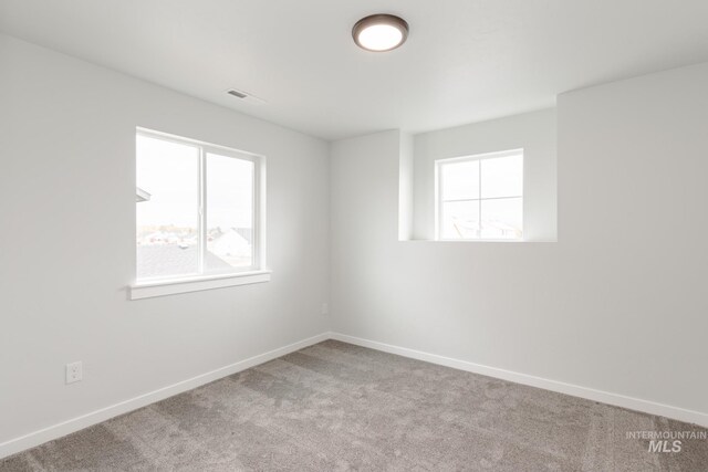 spare room featuring ceiling fan, light colored carpet, and vaulted ceiling