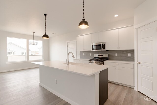 kitchen with an island with sink, stainless steel appliances, and light hardwood / wood-style floors