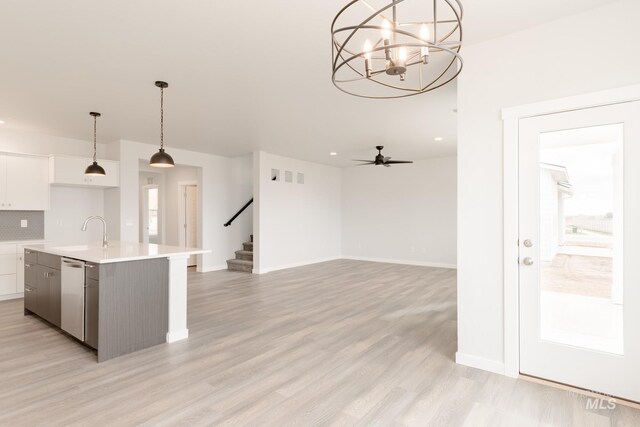 kitchen featuring appliances with stainless steel finishes, white cabinets, pendant lighting, a center island, and ceiling fan