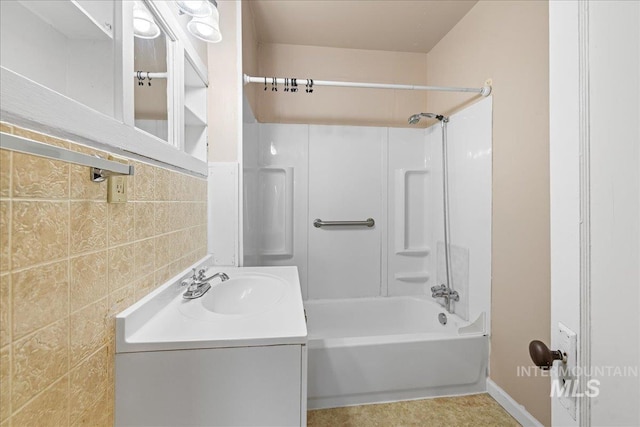 bathroom featuring vanity, shower / bath combination, and tile walls