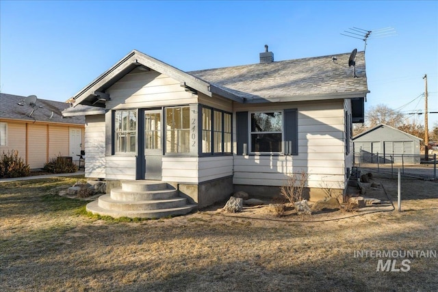 bungalow-style house featuring a front lawn and a sunroom