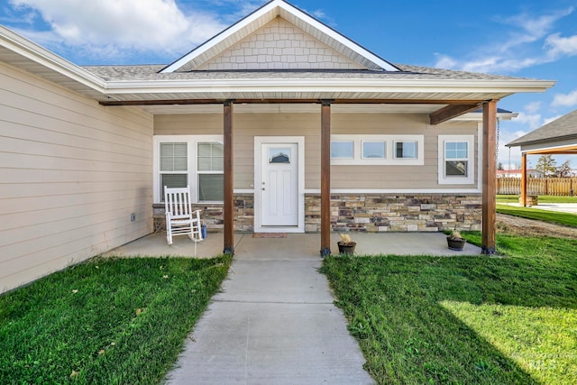 doorway to property featuring a yard and covered porch