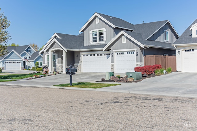 craftsman-style house with fence, board and batten siding, driveway, and an attached garage