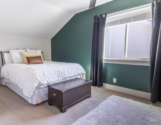 bedroom featuring lofted ceiling and carpet