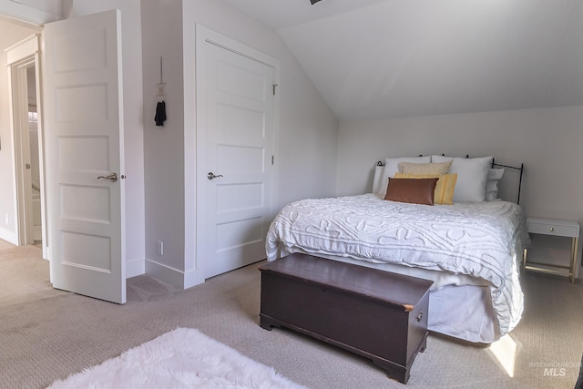 carpeted bedroom with vaulted ceiling and baseboards