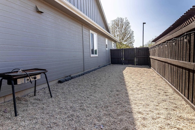 view of home's exterior featuring fence, board and batten siding, and a gate