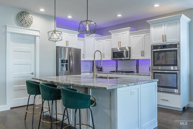 kitchen with recessed lighting, light stone countertops, tasteful backsplash, appliances with stainless steel finishes, and dark wood finished floors