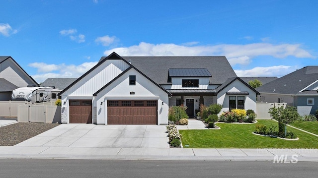 modern inspired farmhouse with a front yard, a standing seam roof, fence, and metal roof