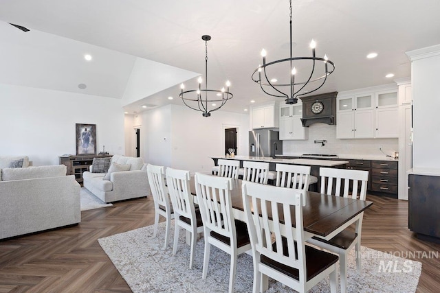 dining room with a notable chandelier, lofted ceiling, and recessed lighting