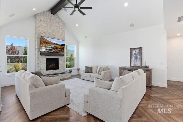 living area with high vaulted ceiling, baseboards, a ceiling fan, beam ceiling, and a stone fireplace