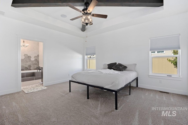 carpeted bedroom featuring baseboards, visible vents, a ceiling fan, and a raised ceiling