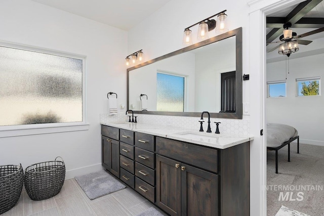 full bathroom featuring baseboards, double vanity, a sink, and a ceiling fan