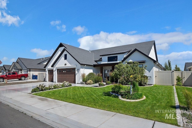modern farmhouse featuring a gate, a garage, a front lawn, and concrete driveway