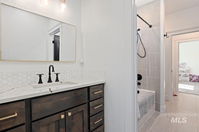 bathroom featuring tile patterned flooring, vanity, tasteful backsplash, and bathtub / shower combination