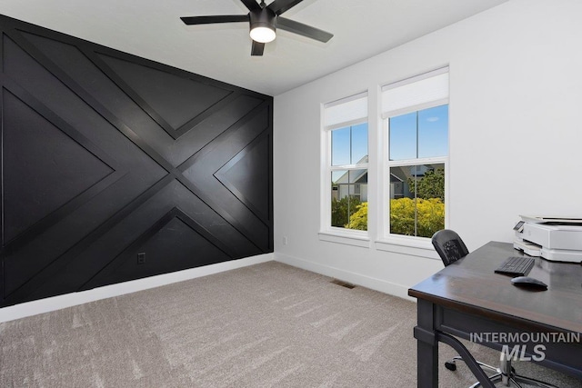 office space with light colored carpet, visible vents, ceiling fan, and baseboards