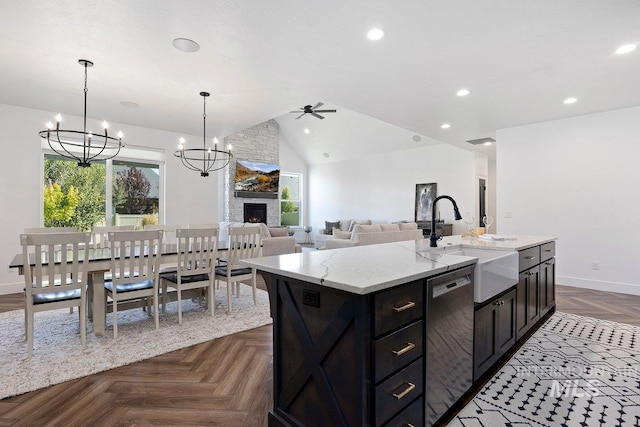 kitchen with stainless steel dishwasher, ceiling fan with notable chandelier, lofted ceiling, and plenty of natural light