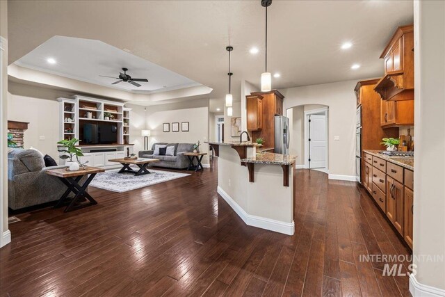 kitchen with stainless steel appliances, arched walkways, a peninsula, and open floor plan