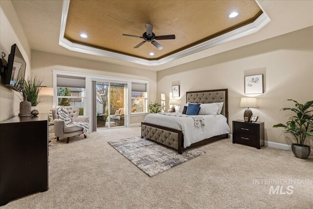 bedroom with a tray ceiling, baseboards, carpet, and ornamental molding