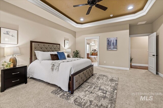 bedroom with crown molding, carpet, and a tray ceiling