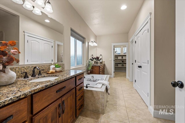 full bath with backsplash, a closet, tile patterned flooring, a bath, and vanity