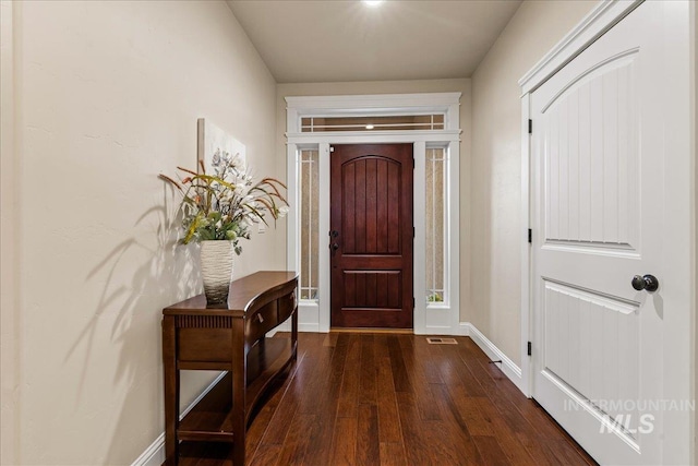 entryway featuring baseboards and dark wood-style floors