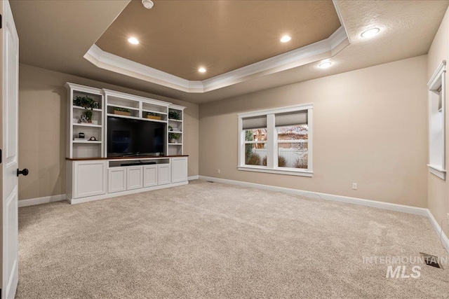 unfurnished living room featuring baseboards, a raised ceiling, light carpet, and crown molding