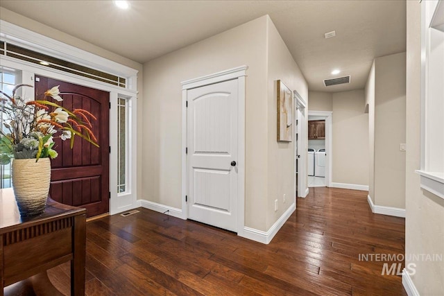 entrance foyer featuring baseboards, visible vents, dark wood-style flooring, and washing machine and clothes dryer