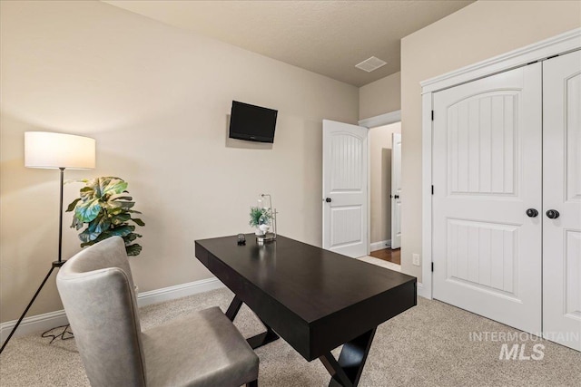 home office with light carpet, visible vents, and baseboards