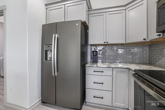 kitchen featuring range with electric cooktop, light stone countertops, stainless steel fridge with ice dispenser, tasteful backsplash, and gray cabinets