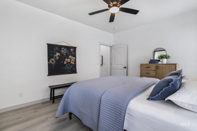 bedroom featuring light wood-type flooring, baseboards, and a ceiling fan