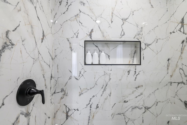room details featuring a marble finish shower