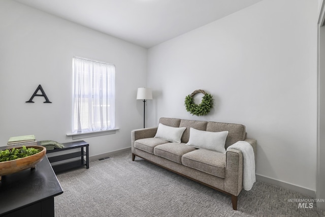 carpeted living area with baseboards and visible vents