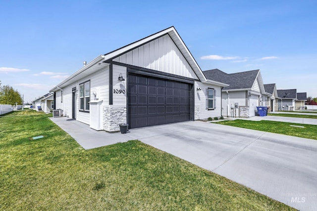modern inspired farmhouse with board and batten siding, an attached garage, driveway, and a front yard