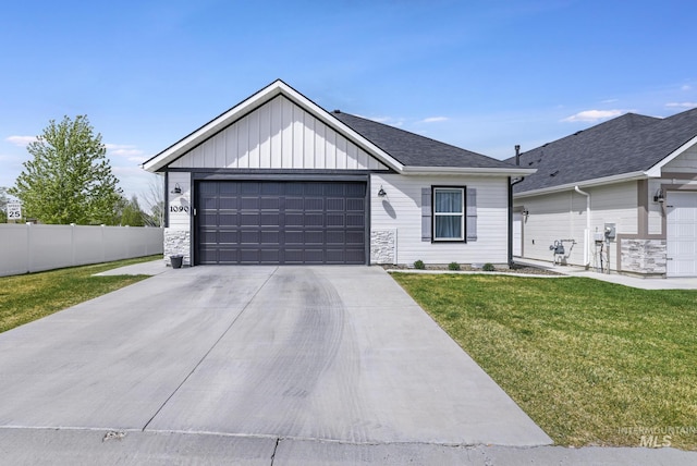 view of front of property with concrete driveway, a front yard, board and batten siding, and fence