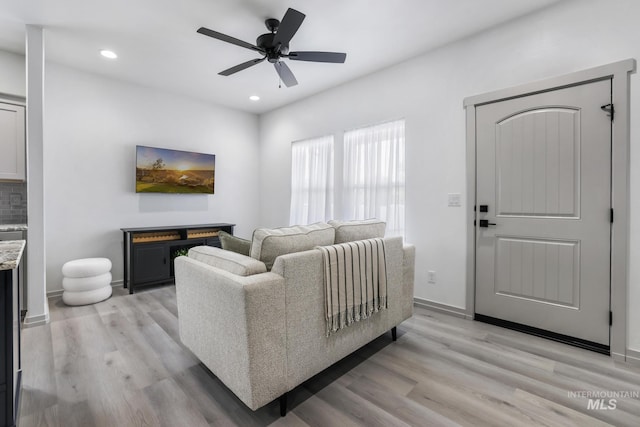living area featuring light wood-type flooring, baseboards, a ceiling fan, and recessed lighting