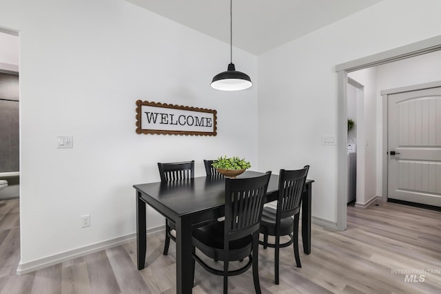 dining space with light wood finished floors and baseboards