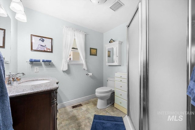 bathroom featuring vanity, toilet, and walk in shower