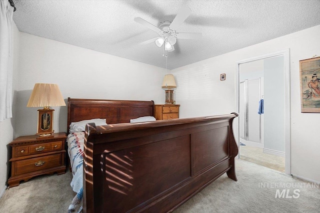 carpeted bedroom featuring ceiling fan and a textured ceiling