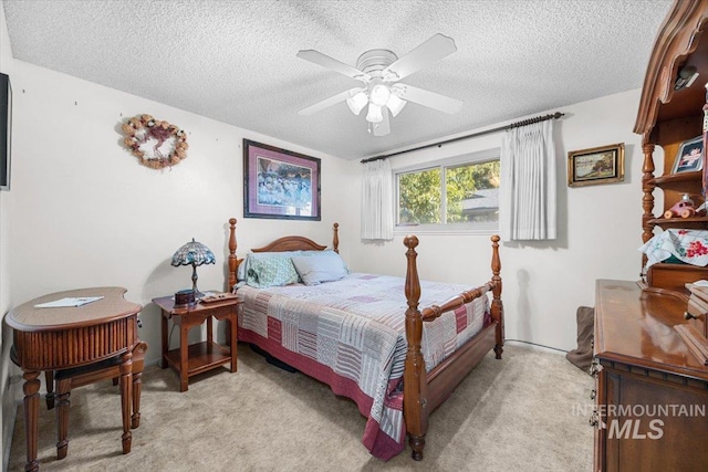 bedroom featuring ceiling fan, light colored carpet, and a textured ceiling