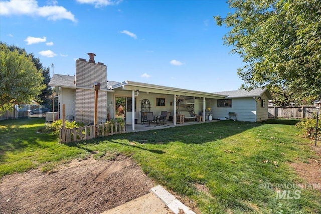 back of house with a patio, central AC, and a lawn