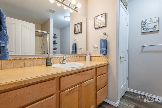 319 N Westminster St, Nampa, ID 83651 - full bath with vanity, wood finished floors, decorative backsplash, baseboards, and a shower