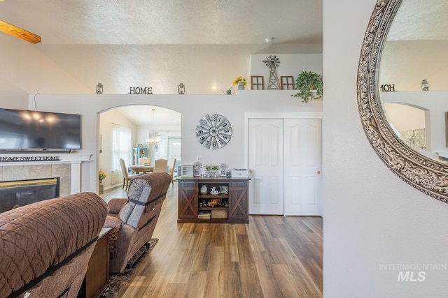 319 N Westminster St, Nampa, ID 83651 - living area featuring wood finished floors, arched walkways, a fireplace, and a chandelier