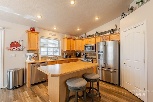 319 N Westminster St, Nampa, ID 83651 - kitchen featuring appliances with stainless steel finishes, a sink, decorative backsplash, light countertops, and light wood-style floors