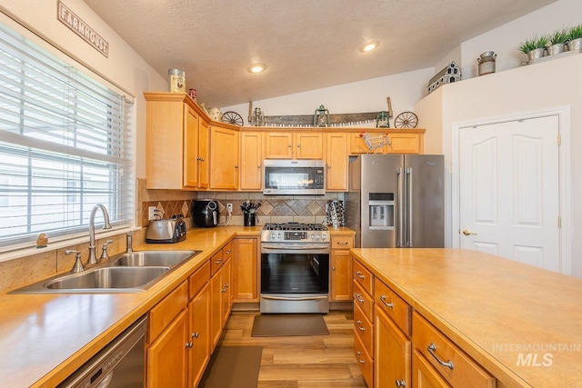 319 N Westminster St, Nampa, ID 83651 - kitchen with appliances with stainless steel finishes, a sink, light countertops, a textured ceiling, and light wood-style flooring