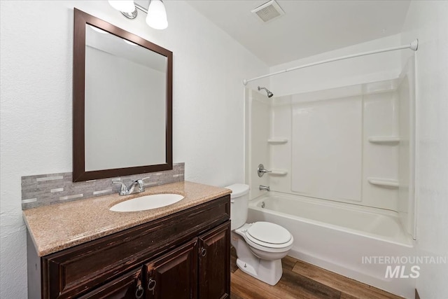 1919 S Banner St, Nampa, ID 83686 - full bathroom with toilet, wood finished floors, vanity, washtub / shower combination, and backsplash