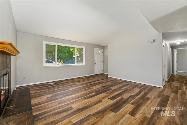 1919 S Banner St, Nampa, ID 83686 - unfurnished living room featuring wood finished floors, a fireplace with flush hearth, and baseboards