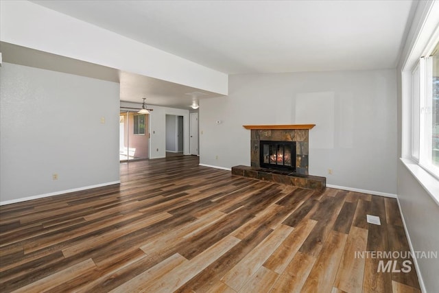 1919 S Banner St, Nampa, ID 83686 - unfurnished living room with wood finished floors, a tile fireplace, and baseboards